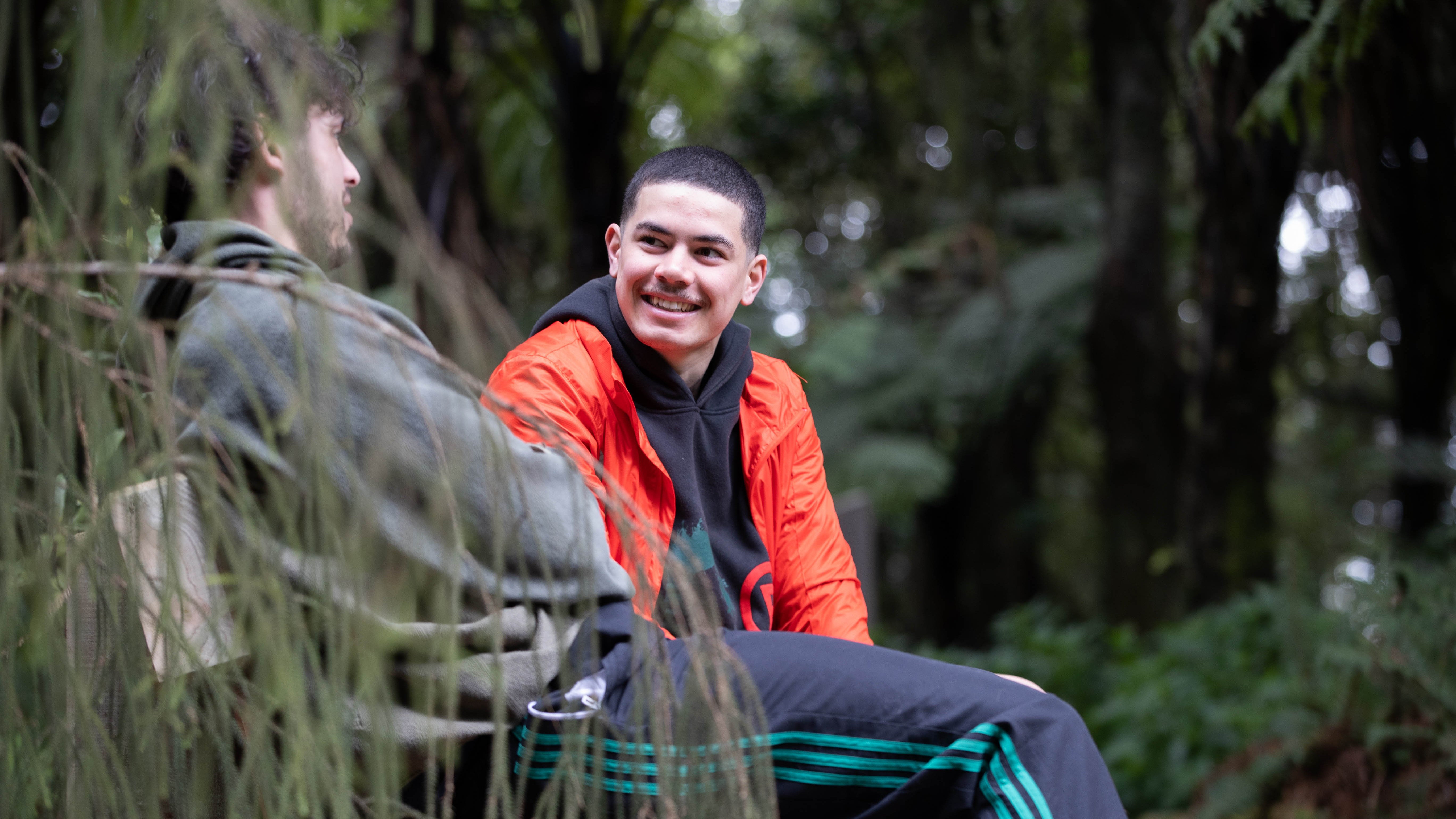two young men sitting on a bench in Otaki nature reserve