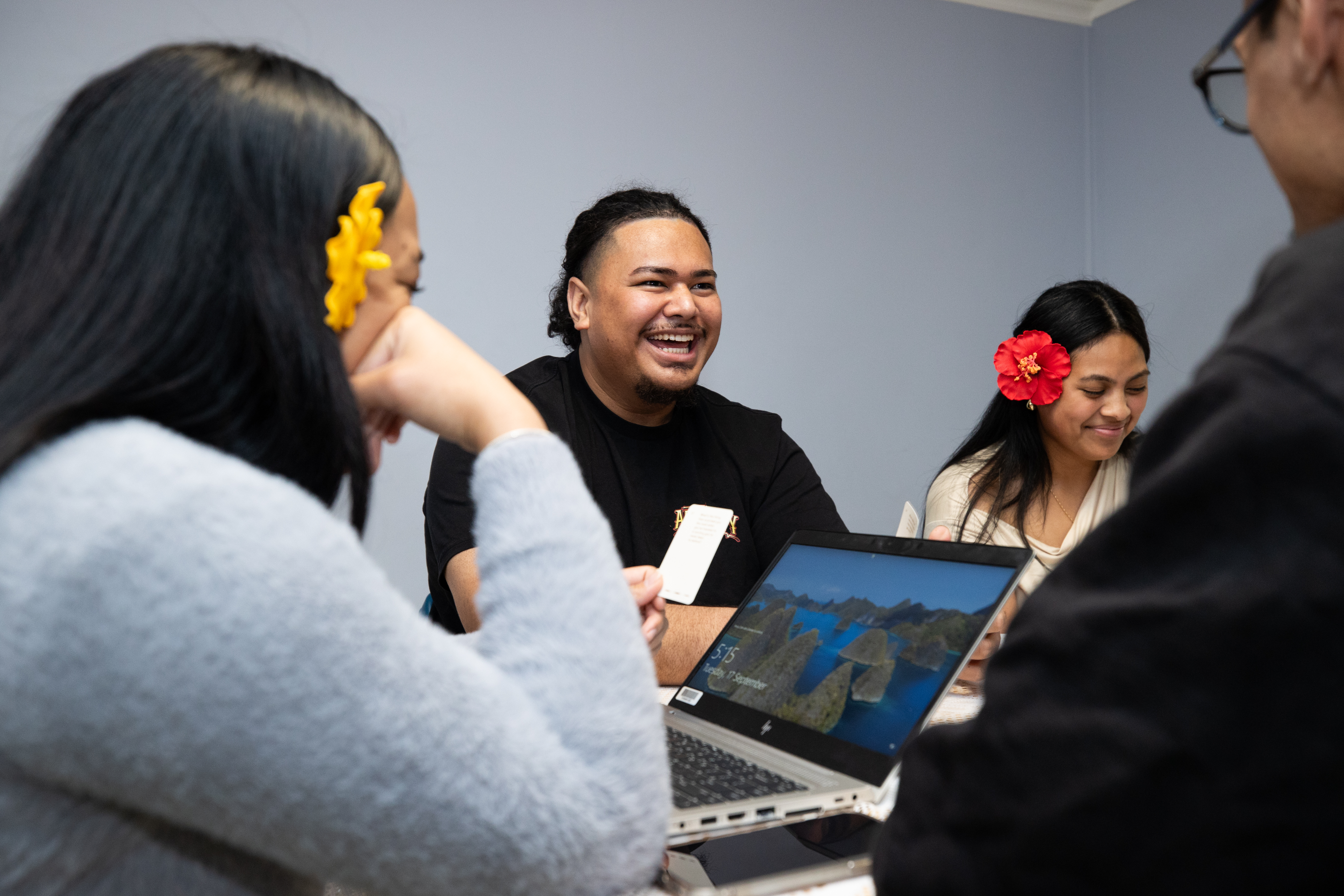 Group of young pacifica people sitting around a table