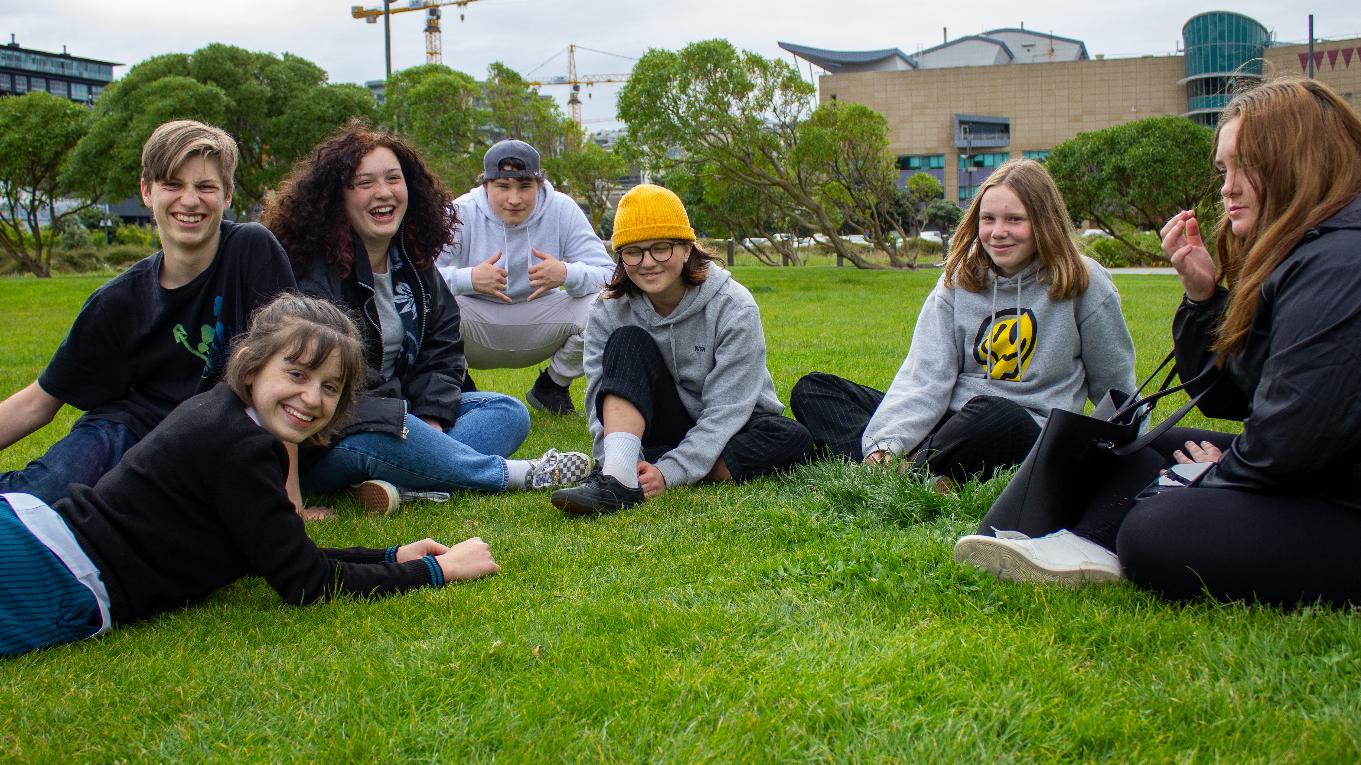 group of young people sit in a park