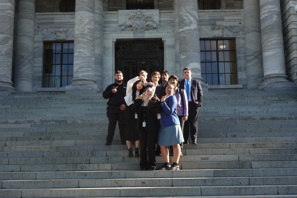 Youth MPs in the Whaikaha PWG pose on the front steps of Parliament
