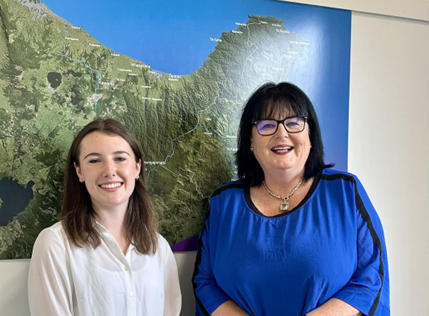 Elenor Walsh, Youth MP, and Dana Kirkpatrick, MP, standing in front of a map of the North Island, smiling