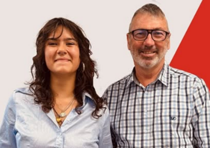 Hineātea Alexander and Hon Dr Duncan Webb smile together in front of a white and red background