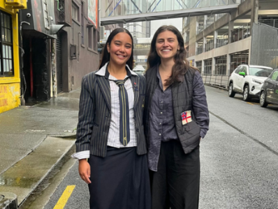 Jorja Simmonds and Chloe Swarbrick stand together smiling on a street in Auckland Central