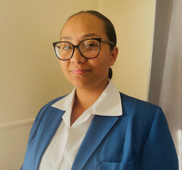 Mariah Wakefield-Otene smiling at the camera, wearing a blue blazer and white blouse