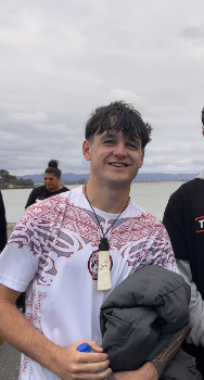 Oscar Duffy smiles for the camera in front of Auckland Harbour