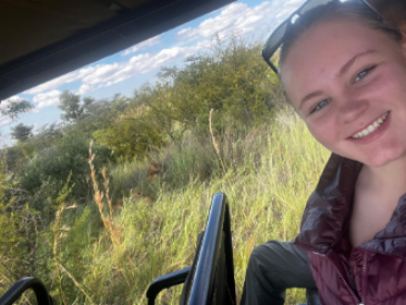 Simone Bisschoff sits in the back of a safari tour vehicle smiling