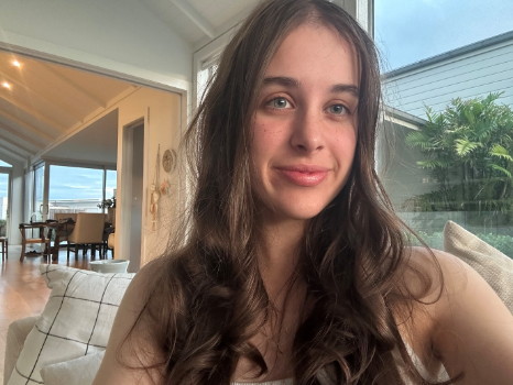 Youth MP Sylvie Macfarlane smiling, sat on a couch in her home