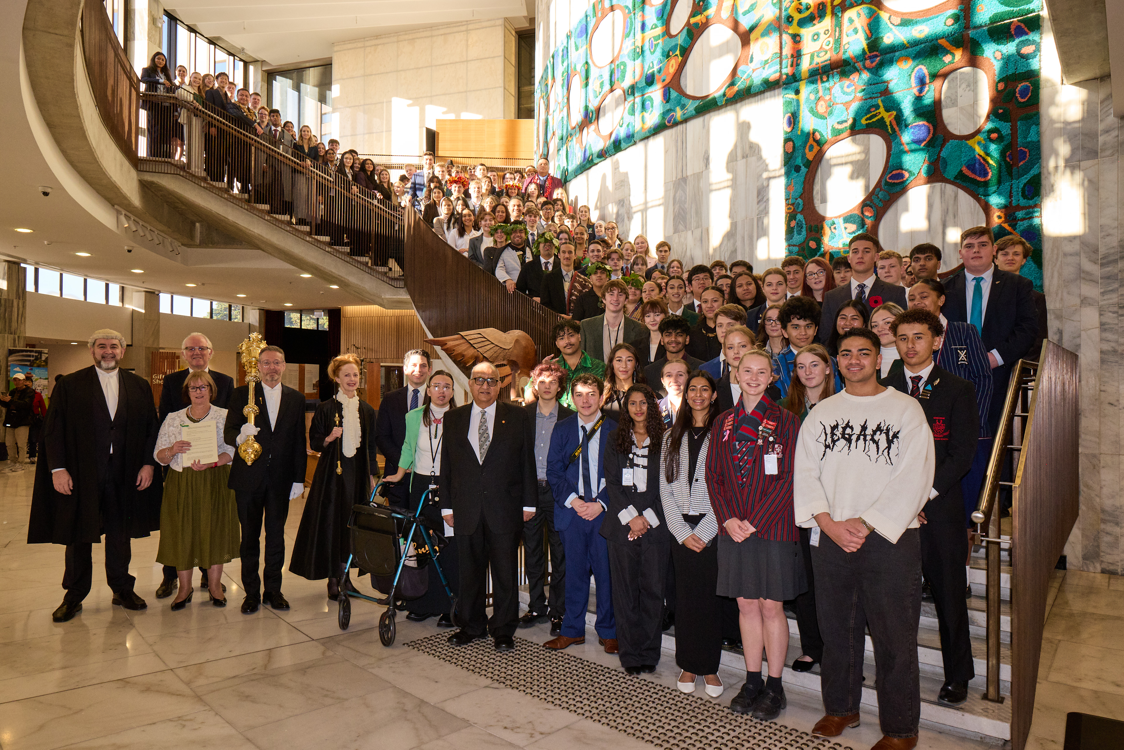 Youth MPs from the 2025 programme stand on the steps inside Parliament